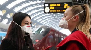 Coronavirus_in ogni luogo con la mascherina. Anche in viaggio. Nella foto due ragazze alla stazione centrale di Milano