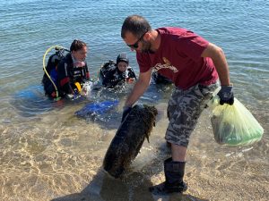 Giovani volontari impegnati nella pulizia del lido di Cagliari